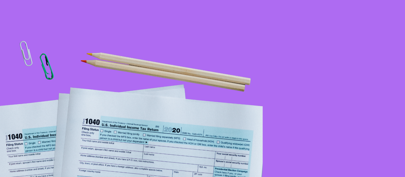1040 federal paper tax forms with pencils and a paperclip on top.